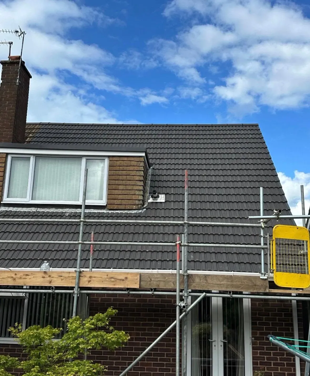 New grey tiled roof with scaffolding up, by Coventry Roofing Group