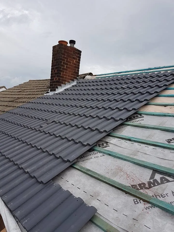 Roofer replacing broken tiles on a Coventry terraced house